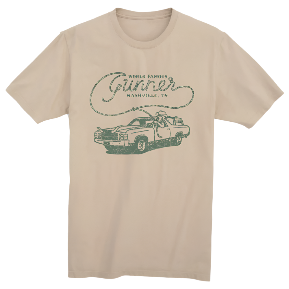The WORLD FAMOUS TEE by GUNNER is a beige shirt with a green vintage car graphic, a person on the hood, and World Famous Gunner Nashville, TN script, embodying Southern hospitality in timeless style.