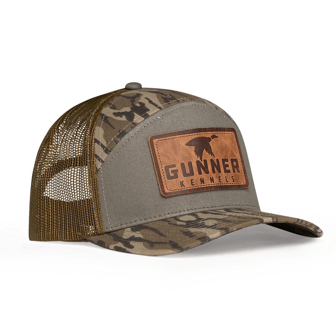 The GUNNER BOTTOMLAND HAT features Mossy Oak Bottomland camo, a mesh back, and a brown leather patch on the front with the GUNNER logo and dog silhouette.