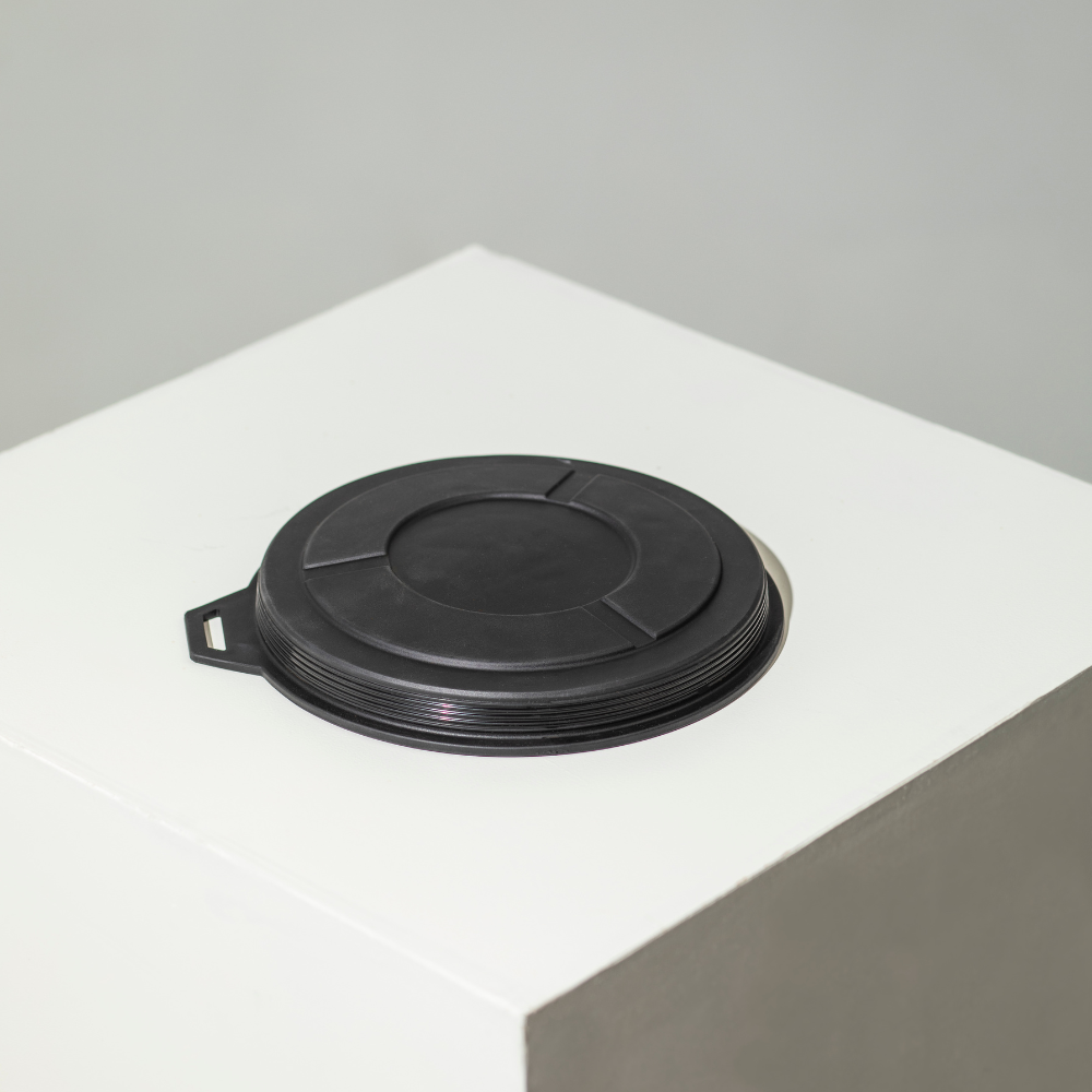 A stack of black GUNNER Food & Water Bowl Replacement Lids is arranged on a white, angular surface set against a plain light gray background.