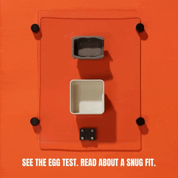 A hand pushes a white block through a square hole so it fits snugly, then tries to push a gray block through the same hole, but it doesn’t fit. Text reads: See the egg test. Read about a snug fit in the kennel.