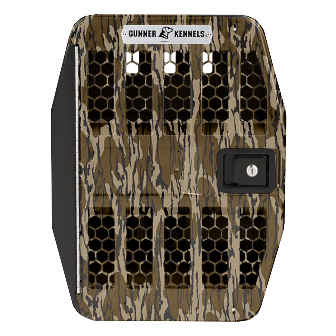 Front view of a GUNNER G1™ KENNEL DOOR featuring a Mossy Oak's Bottomland pattern (a brown and tan camo pattern), secure aluminum frame, black honeycomb ventilation holes, black latch lock, and the Gunner logo at the top.