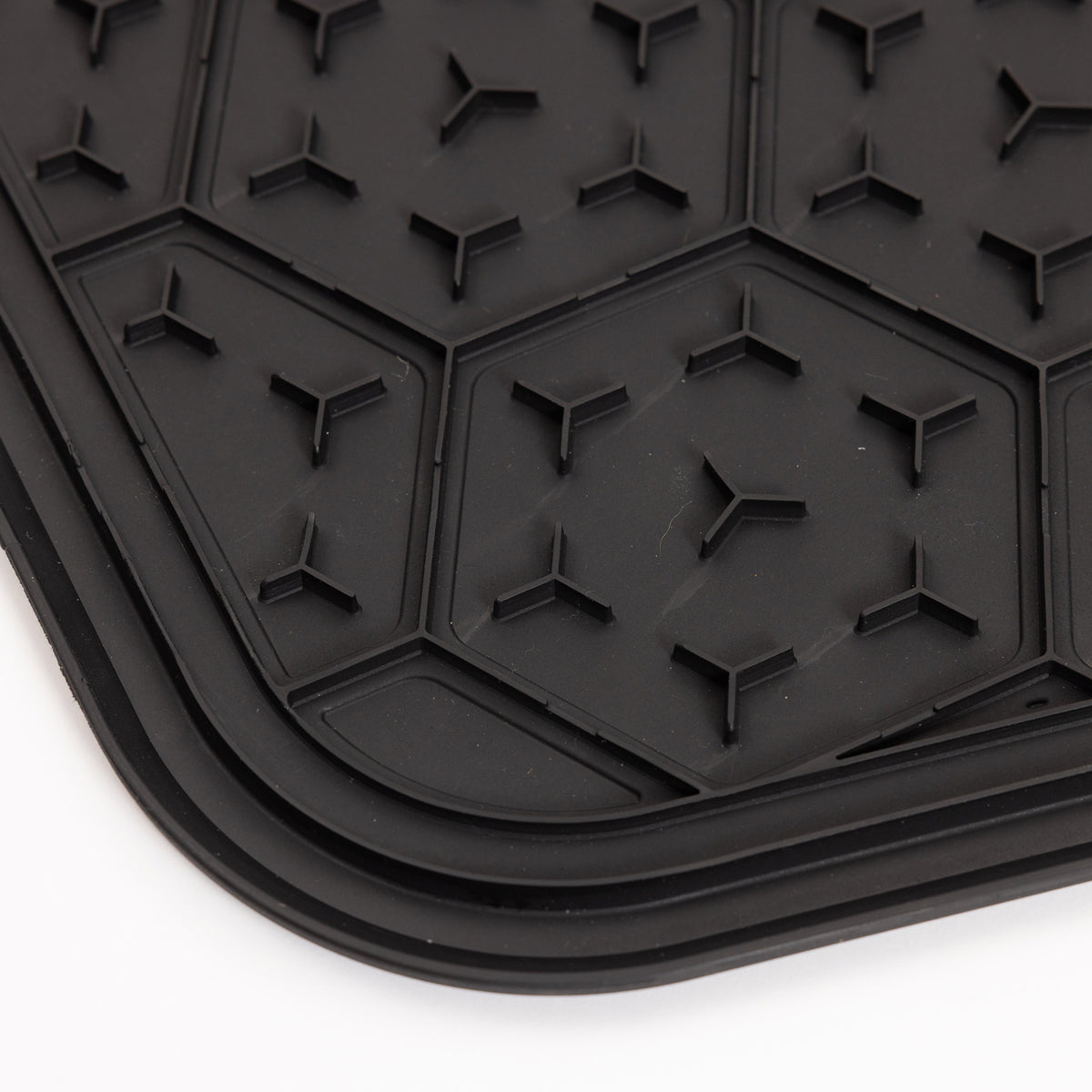 Close-up of the GUNNER BOWL MAT - BLACK, a slip-resistant black rubber mat featuring a hexagonal pattern with small raised triangular shapes, displayed on a white background.