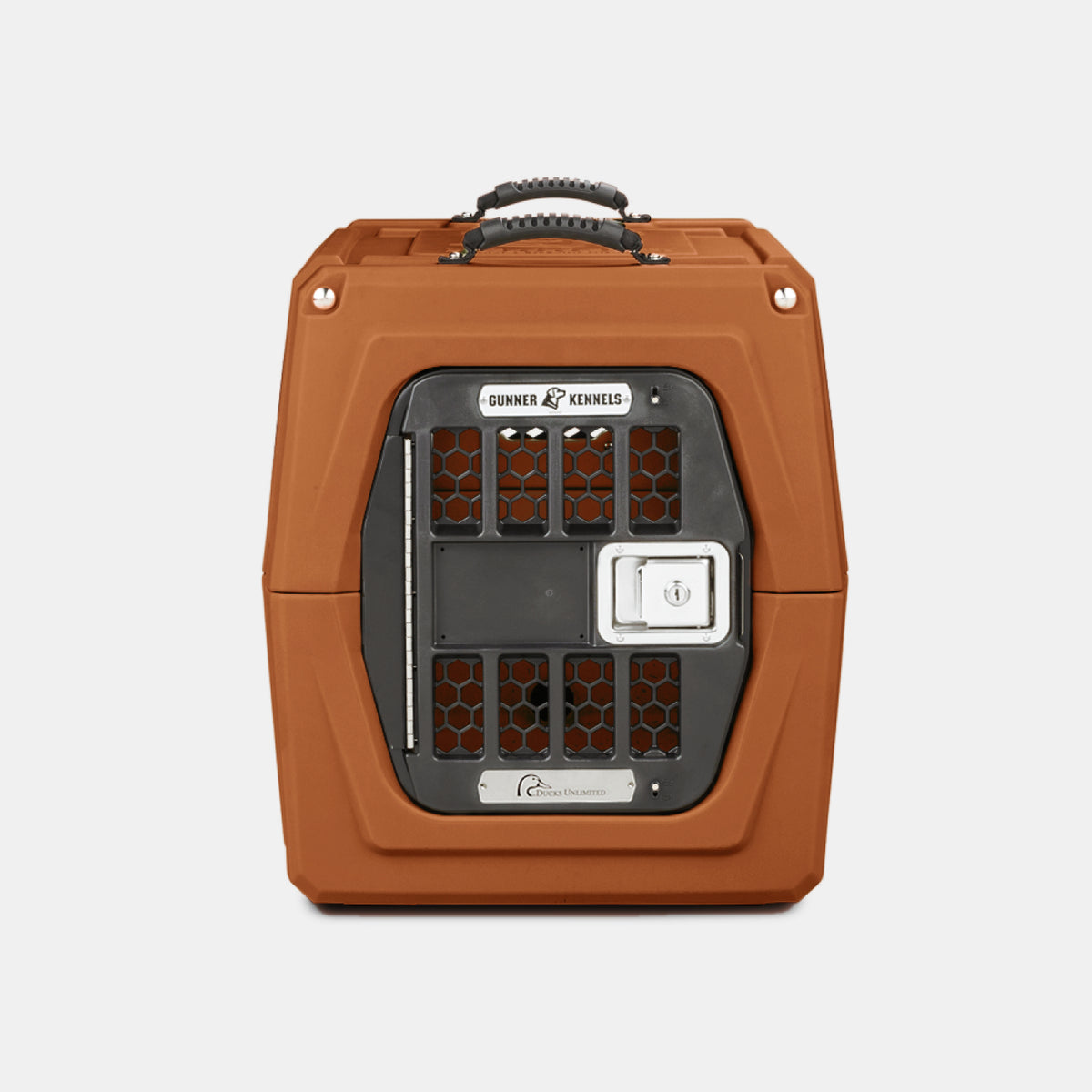 A brown hard-shell pet kennel, perfect as an outdoor gear essential, features a black metal door, a handle on top, and a silver label reading Gunner Kennels on the front. The kennel is set against a plain white background.