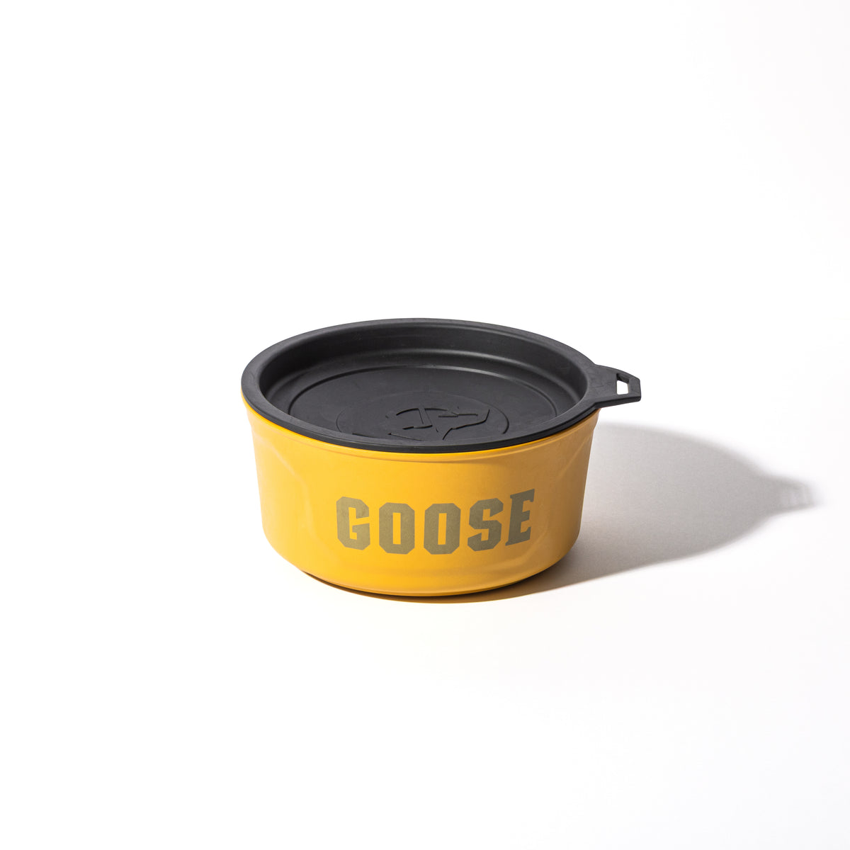 The GUNNER DOG BOWL - Marigold by GUNNER is a yellow bowl with a black lid and handle, marked GOOSE in large gray letters, designed as a stylish travel dog bowl and shown on a plain white background.