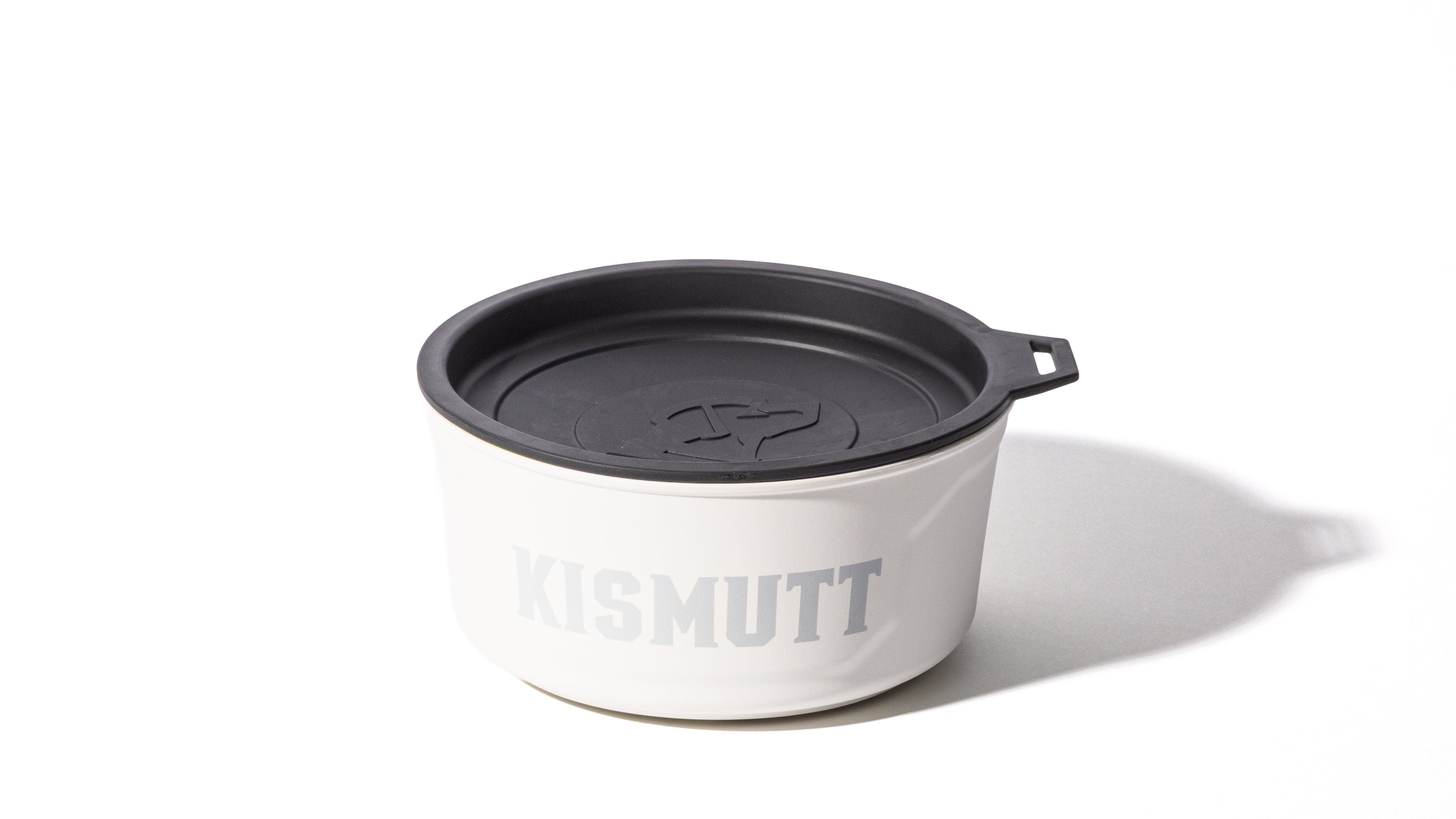 A white container with a black lid and the word KISMUTT printed in large grey letters on the side, ideal for storing working dog supplies, placed on a white surface with a shadow to the right.