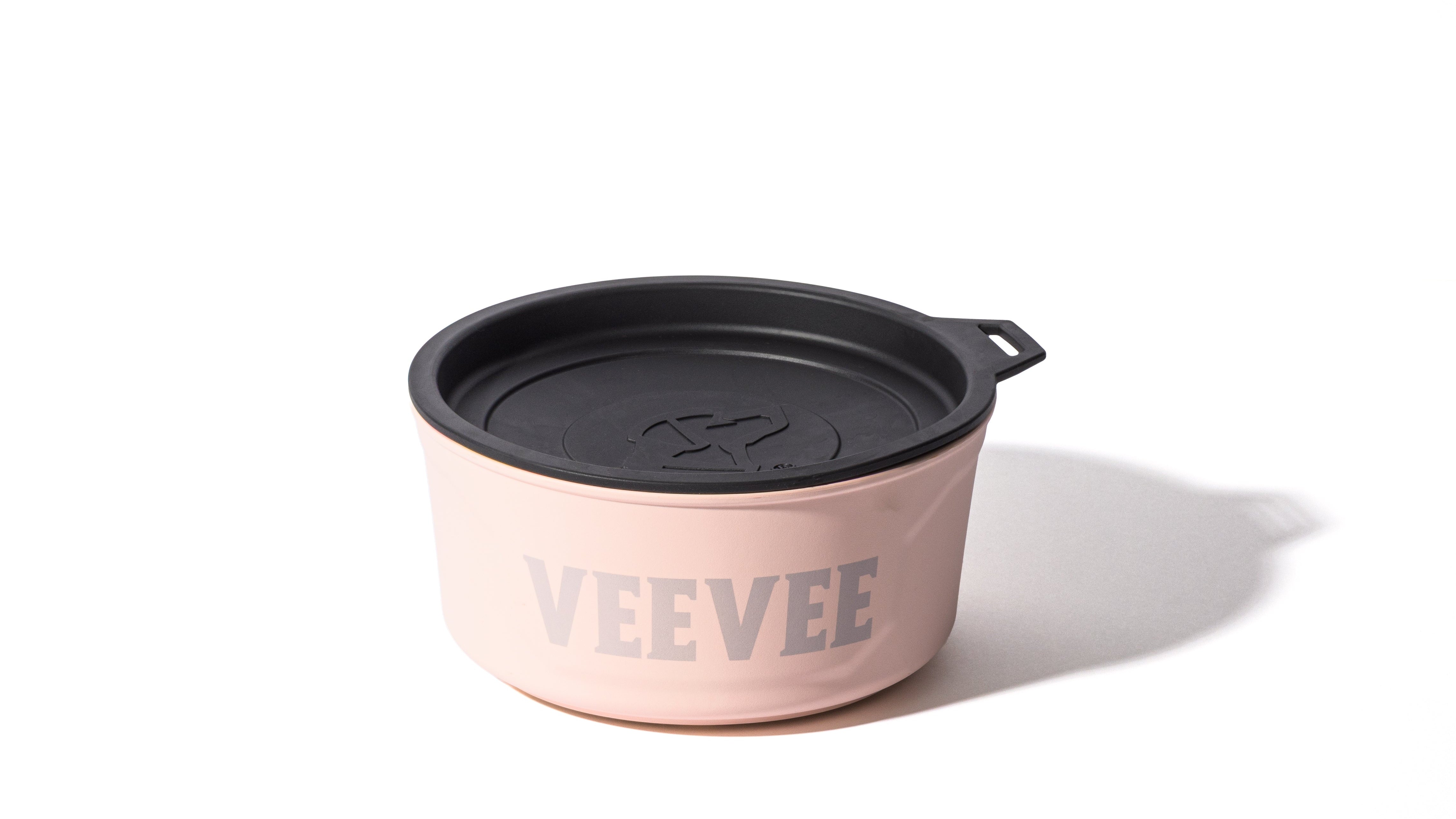 A light pink dog crate with the word VEEVEE printed in large letters on the side, featuring a black lid and a small tab handle, set against a white background with a shadow to the right.