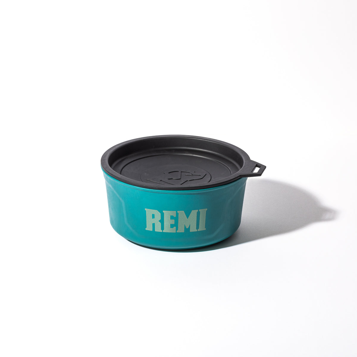 The GUNNER DOG BOWL - Teal by GUNNER, with a black lid and REMI in bold white letters inspired by Color Fetch 2025, is displayed on a white background.