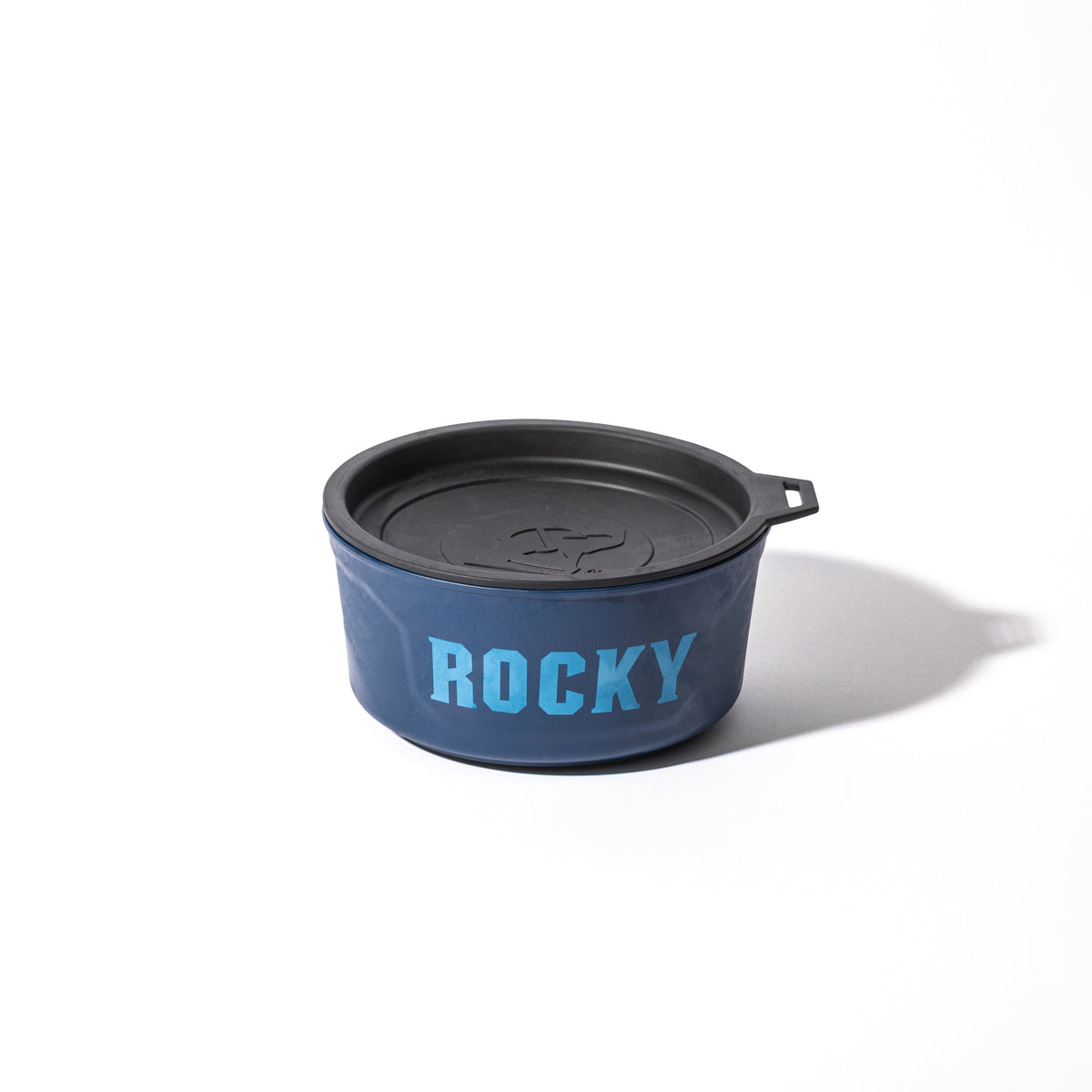 The GUNNER DOG BOWL - NAVY by GUNNER features a black lid and ROCKY in bold light blue letters, from the limited-edition Color Fetch collection, shown on a white background.