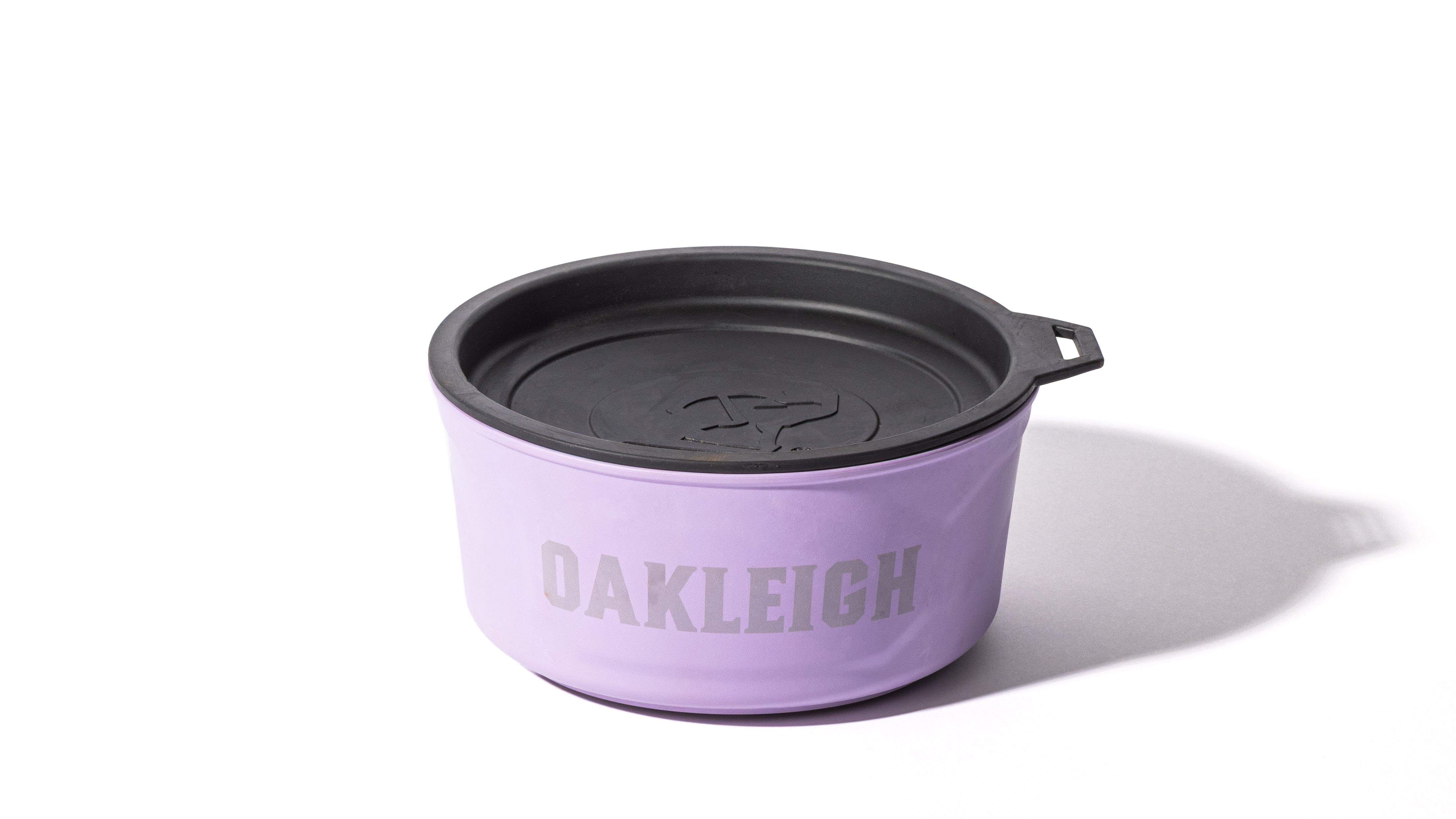 A lavender container with a black lid, featuring the word OAKLEIGH in large gray letters on the side—ideal for storing working dog treats or outdoor gear—set on a white background with a shadow.