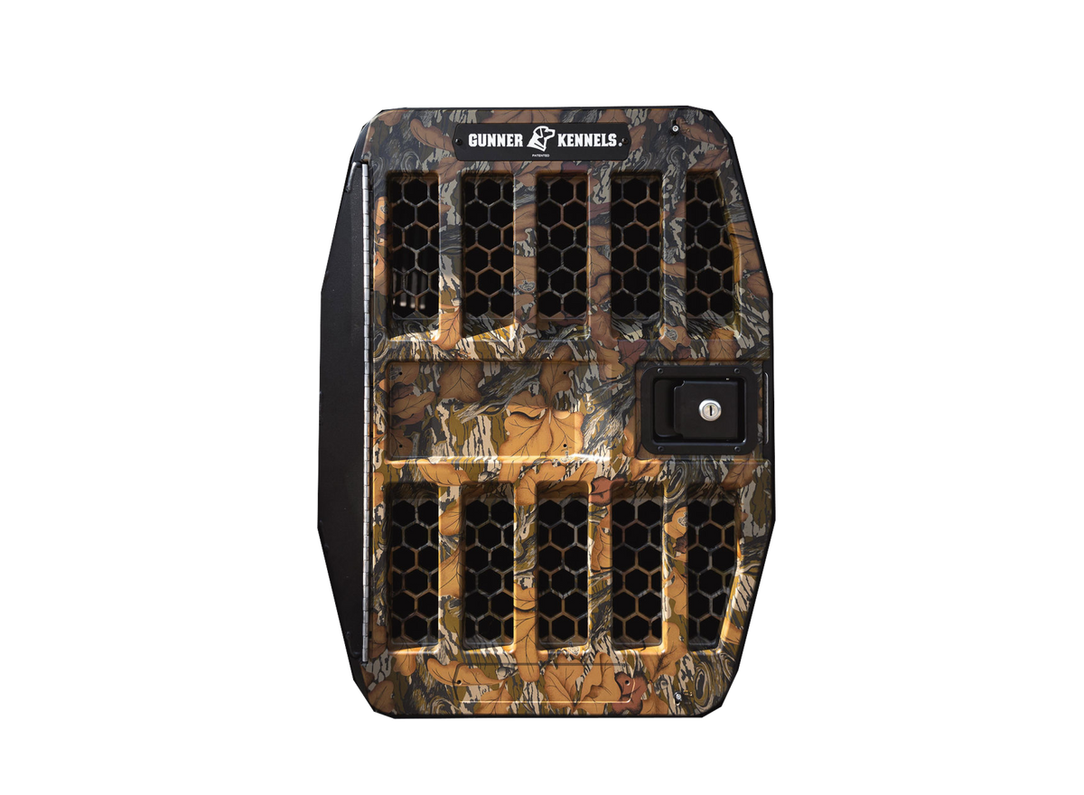 A rugged GUNNER G1™ Kennel Door in Mossy Oak Fall Foliage, featuring a honeycomb design, right-side lock, and GUNNER branding on top, set against a plain white background.