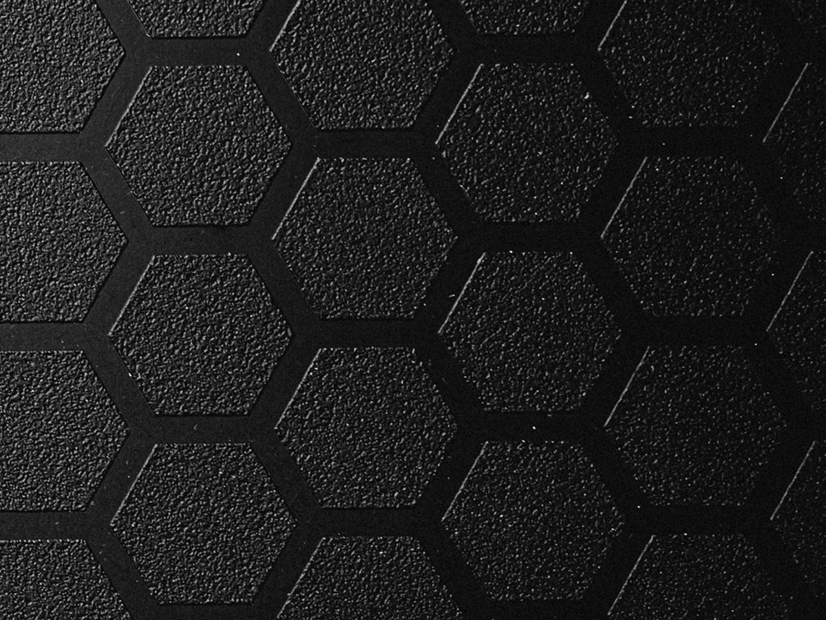 Close-up of the GUNNER PERFORMANCE PAD’s textured black surface with a repeating hexagonal pattern, raised edges, and grainy finish—crafted for durability as a tough-skin insert in sporting dog crates.