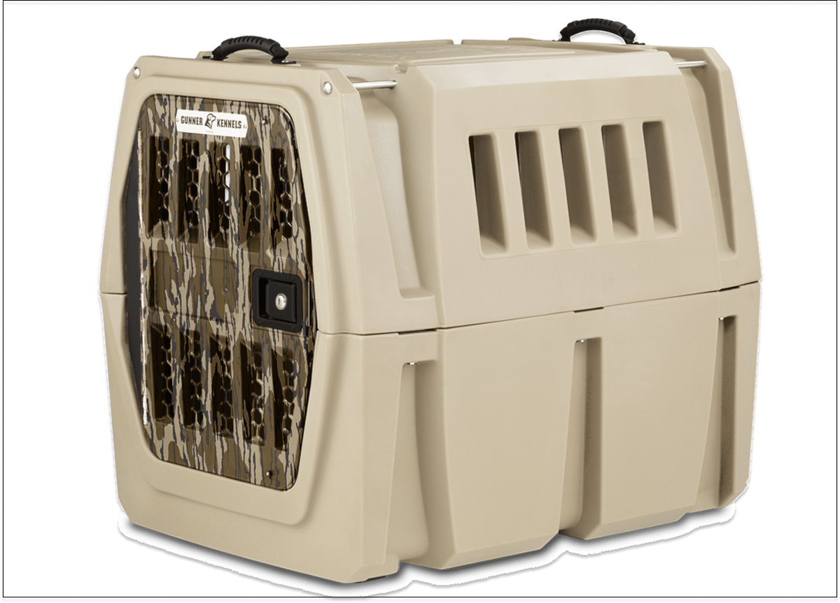 The GUNNER G1™ Kennel - GUNNER YARD is a tan, double-walled crate with a camouflage metal door, black top handles, side ventilation slots, and offers shock protection for your pet.