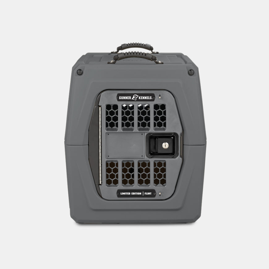 A gray, hard-sided dog crate with a secure, vented door, black handle on top, and labeled Gunner Kennels on the front—perfect outdoor gear for traveling with your hunting dog.