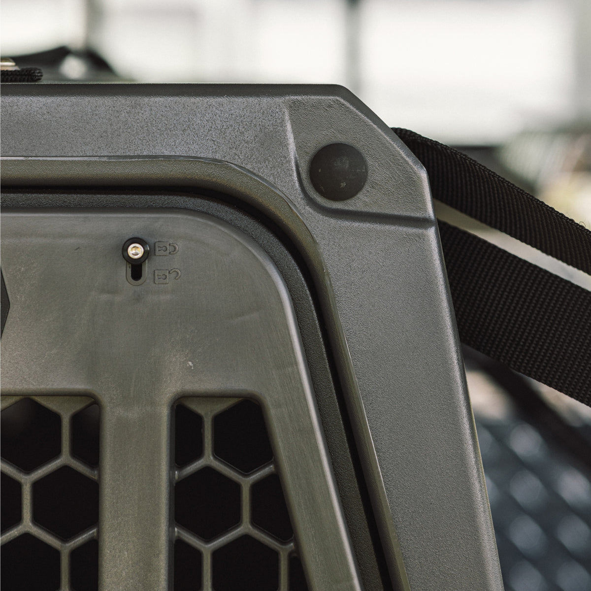 Close-up of the G1™ KENNEL - FLINT by GUNNER, highlighting its durable plastic, black strap, honeycomb-patterned ventilation holes, and latch—crafted for unmatched reliability.