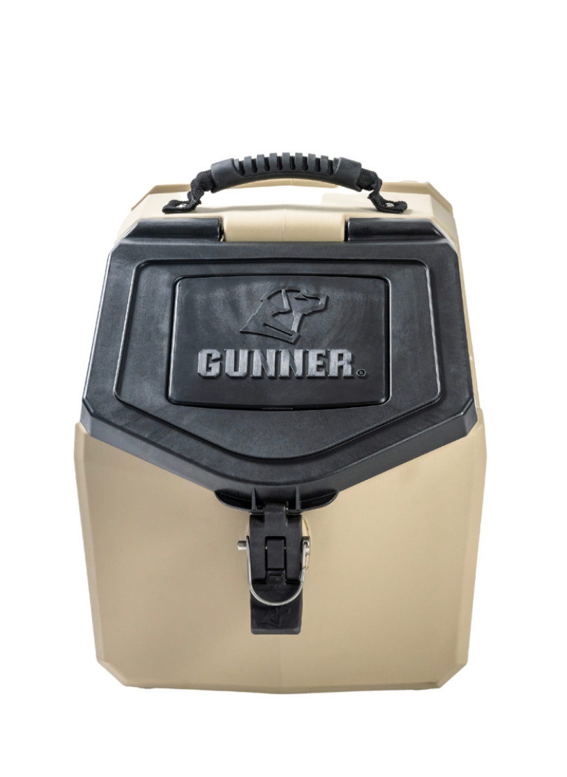 A tan and black hard-sided dog crate with a sturdy handle on top, a secure latch, and the word GUNNER embossed on the front panel beneath a dog logo.
