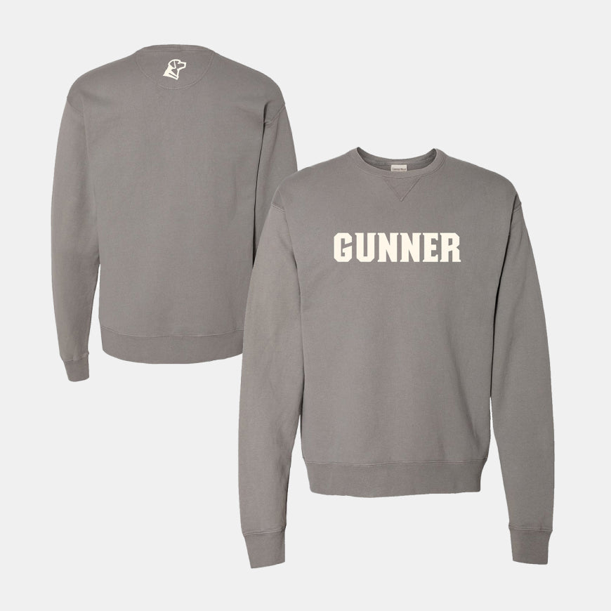 Gray crewneck sweatshirt with the word GUNNER in bold white letters across the chest—a perfect fit for working dog enthusiasts. The back features a small white fist graphic below the collar. Both front and back views are shown.