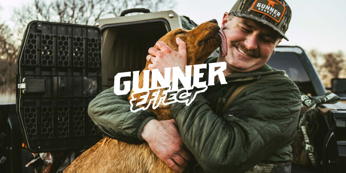 A man in outdoor gear smiles and hugs a brown hunting dog near an open dog crate with GUNNER Effect text overlaying the image.