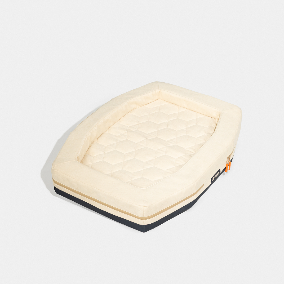 The HOMESTEAD DOG BED Oak by GUNNER is a rectangular, cream-colored pet bed with a quilted surface, raised edges, black base, and orange zipper pull. Durable and easy to clean, it provides lasting comfort. Displayed on a plain white background.