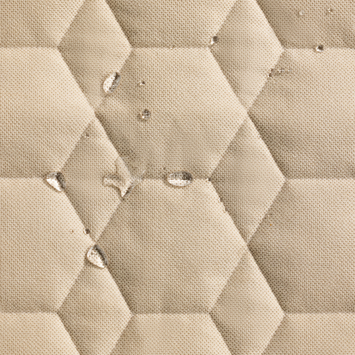 Close-up of GUNNER HOMESTEAD DOG BED Oaks beige fabric with a hexagonal quilted pattern, showing water beading on the surface—demonstrating its durable, water-resistant qualities.