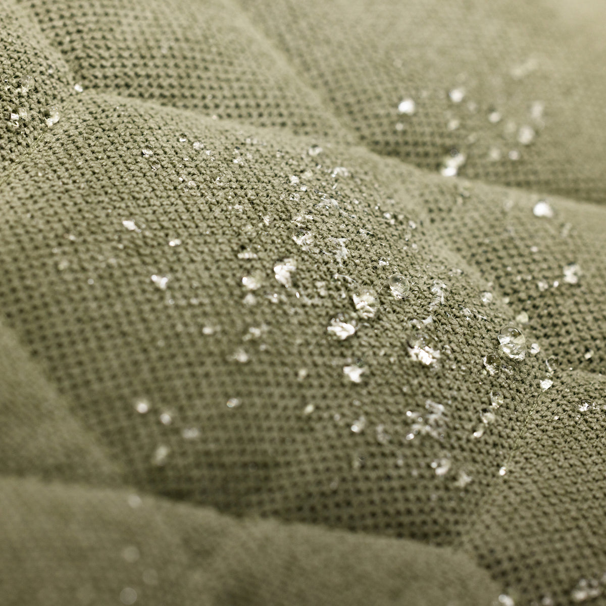 Close-up of water droplets on the textured surface of GUNNERs HOMESTEAD DOG BED in Treeline Green, showcasing its durable, water-resistant fabric.