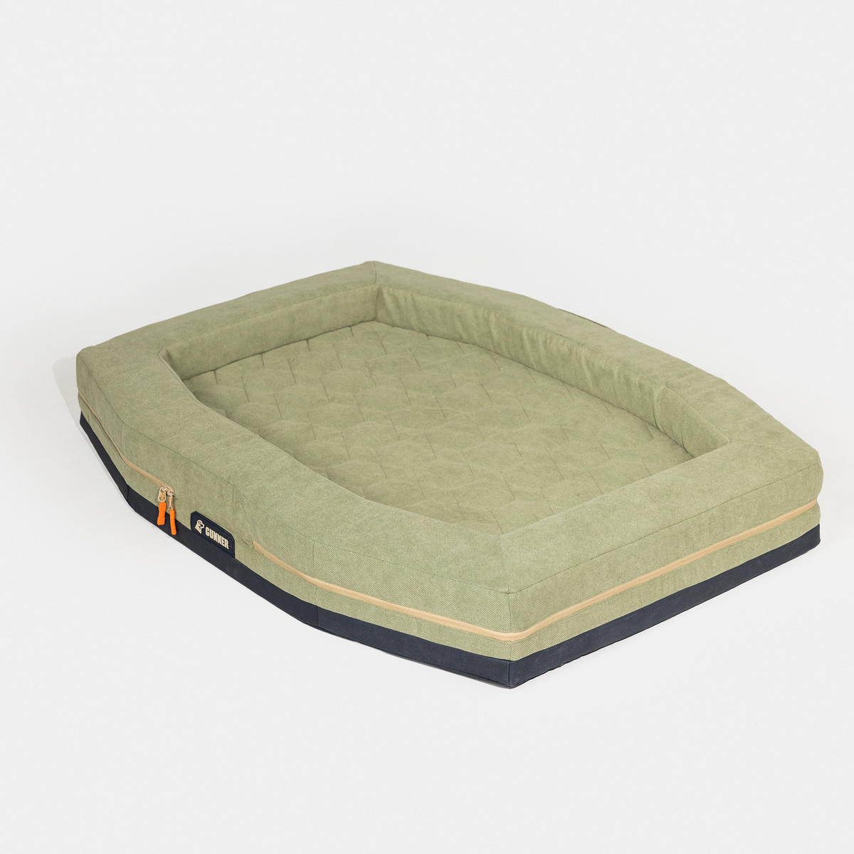The GUNNER HOMESTEAD DOG BED Treeline Green features a rectangular shape with raised edges, quilted olive green surface, beige trim, black base, and an orange side zipper. Durable and long-lasting, its set against a plain white background.