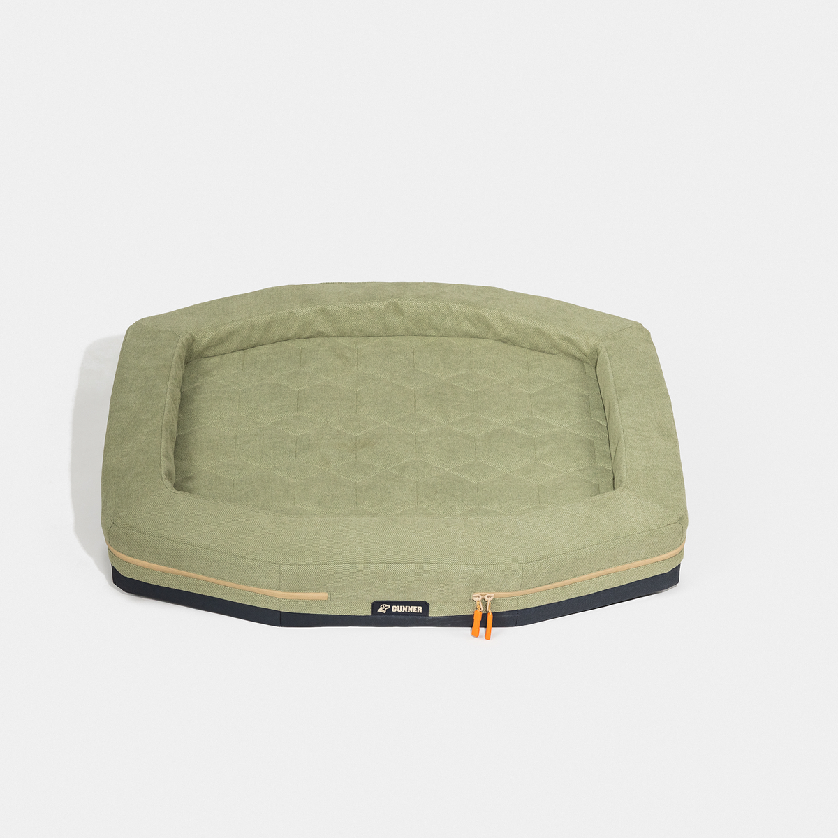 The GUNNER HOMESTEAD DOG BED Treeline Green is a rectangular pet bed with raised edges, a quilted surface, and orange zipper pulls. Durable and easy to clean, it’s shown on a plain white background.