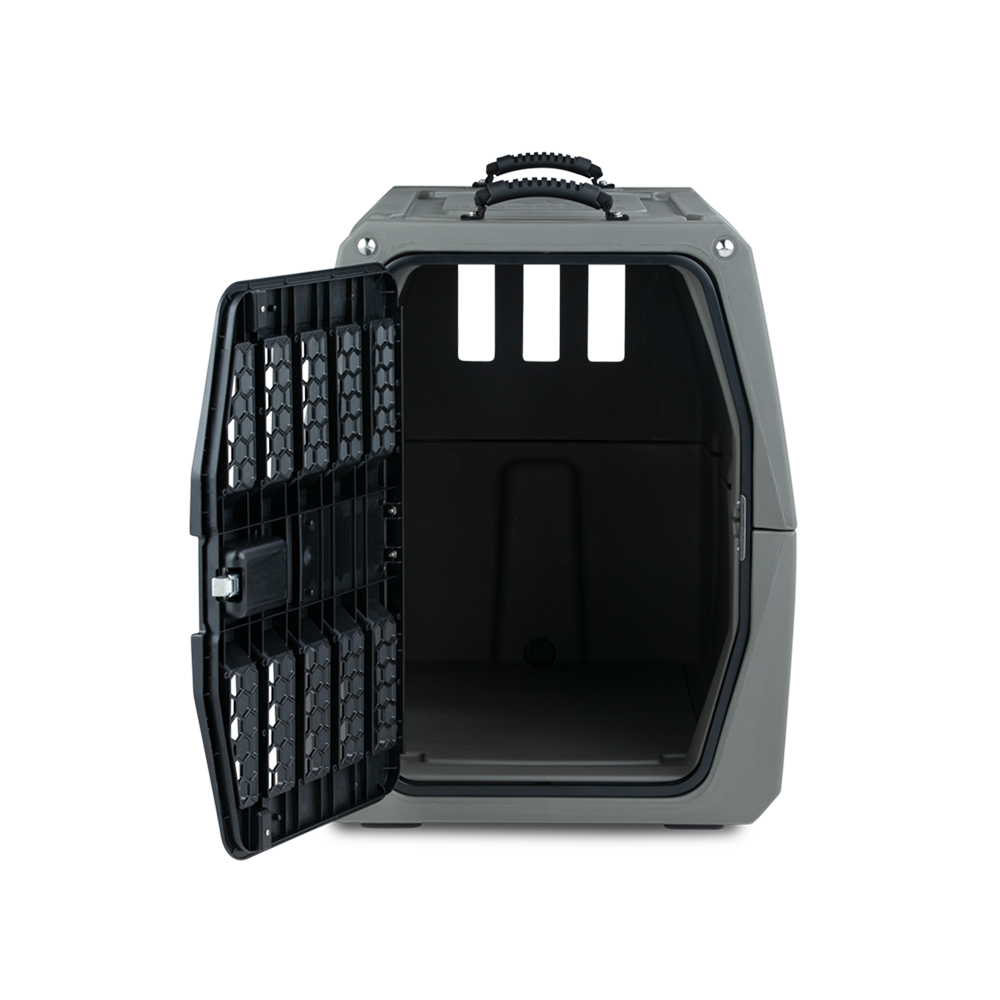The GUNNER G1™ KENNEL in gunmetal features a tough gray plastic build, a side-opening black metal door, three rectangular rear ventilation openings, an empty interior, and a top handle for easy carrying.