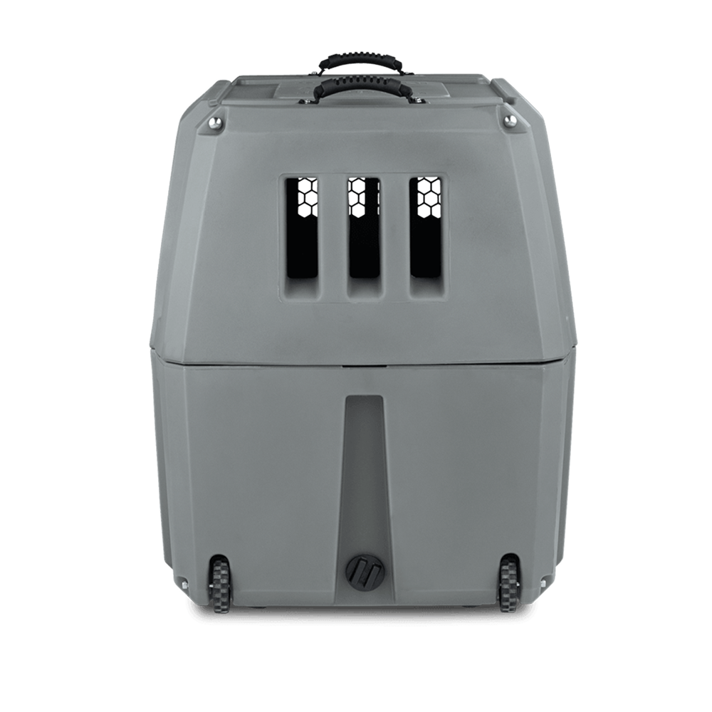 The GUNNER G1™ KENNEL in gunmetal, with ventilation slats, a top handle, and bottom wheels, is the ideal hard-sided dog crate for safe travel.