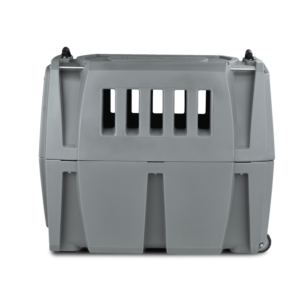 The GUNNER G1™ KENNEL - GUNMETAL is a durable gray plastic dog crate with front ventilation slats and wheels, designed to securely and safely transport animals.