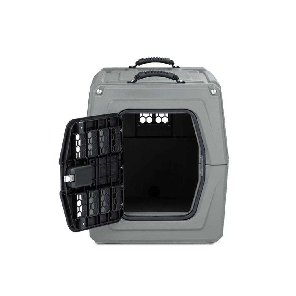 The GUNNER G1™ KENNEL - GUNMETAL is a gray, hard-sided dog crate with a textured top handle, an open black grated door, and vent holes on the sides and back for airflow.