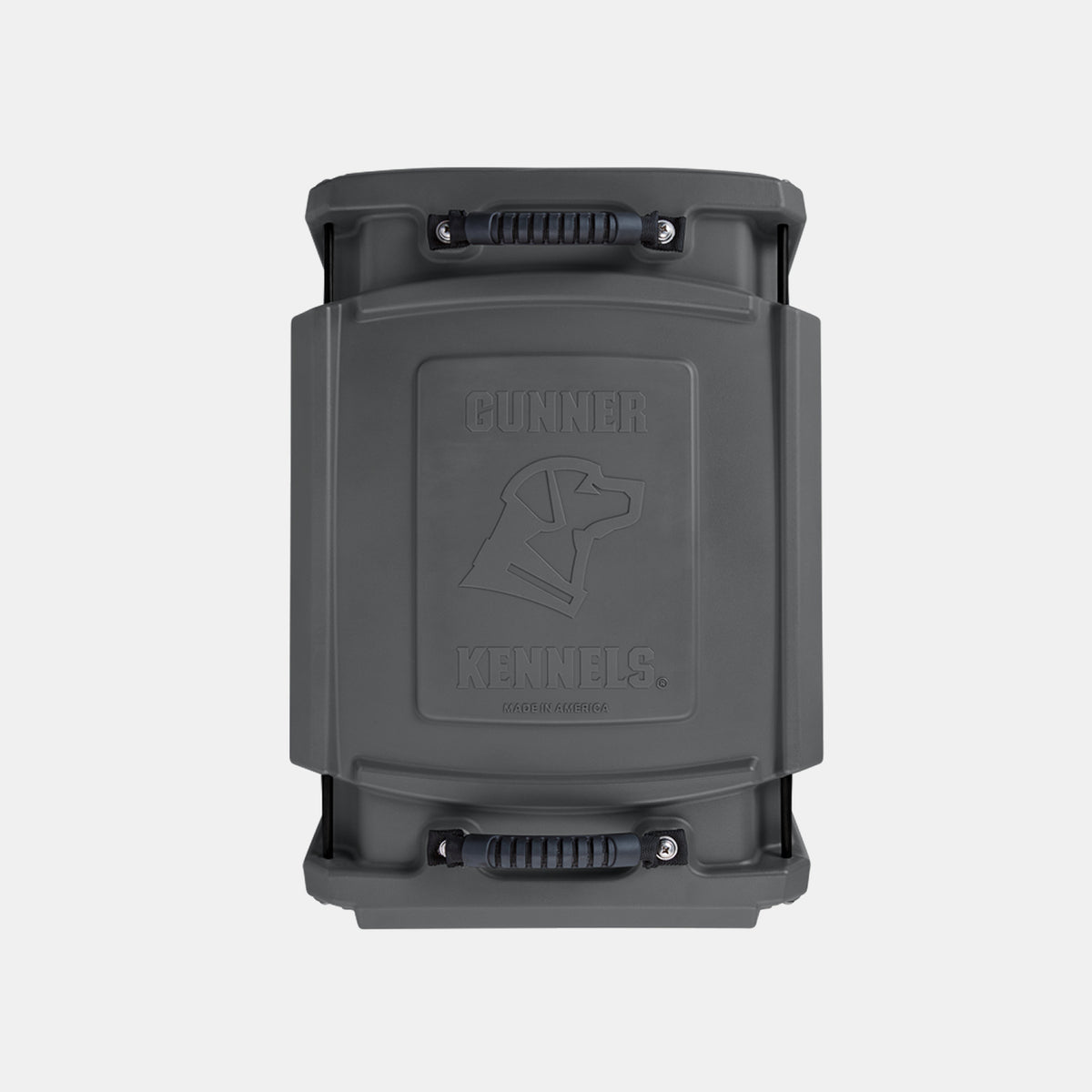 A dark gray Gunner Kennels dog crate, designed for outdoor gear enthusiasts and working dogs, is shown from above, featuring a molded logo of a dog’s head and the words GUNNER KENNELS on the lid, with sturdy black handles on each end.