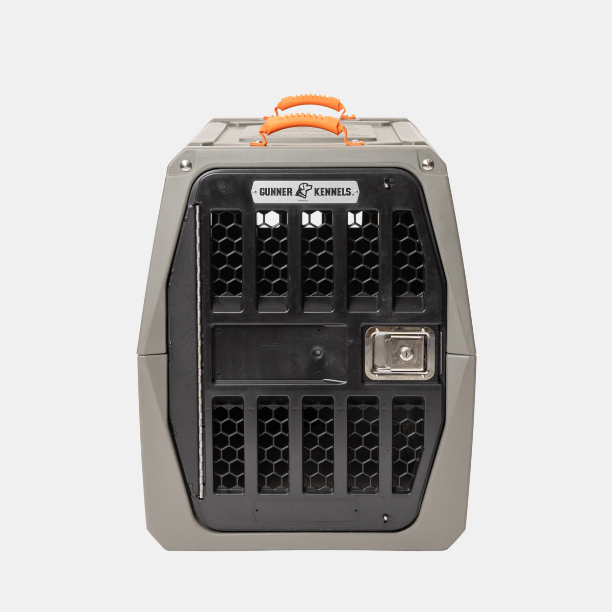 A blaze orange ridged rubber handle designed for GUNNER kennels is shown attached to a hard-sided gray and black pet kennel. The kennel, made from GUNNER-Grade materials, features ventilation holes, a metal door with a secure latch, and the Gunner Kennels label. The background is plain white.