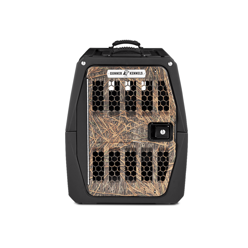 The GUNNER G1™ KENNEL - BLACK/SHADOW GRASS features Mossy Oak Shadow Grass camo on the front and sides, a black frame, and a secure latch door—designed for safe pet transport. The GUNNER brand is displayed at the top.