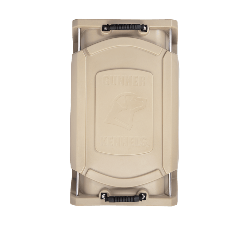 Top view of the GUNNER G1™ KENNEL - MOSSY OAK BOTTOMLAND TAN, a beige hard-sided crate with black handles on each end. The lid displays an embossed dog head and the words GUNNER KENNELS.