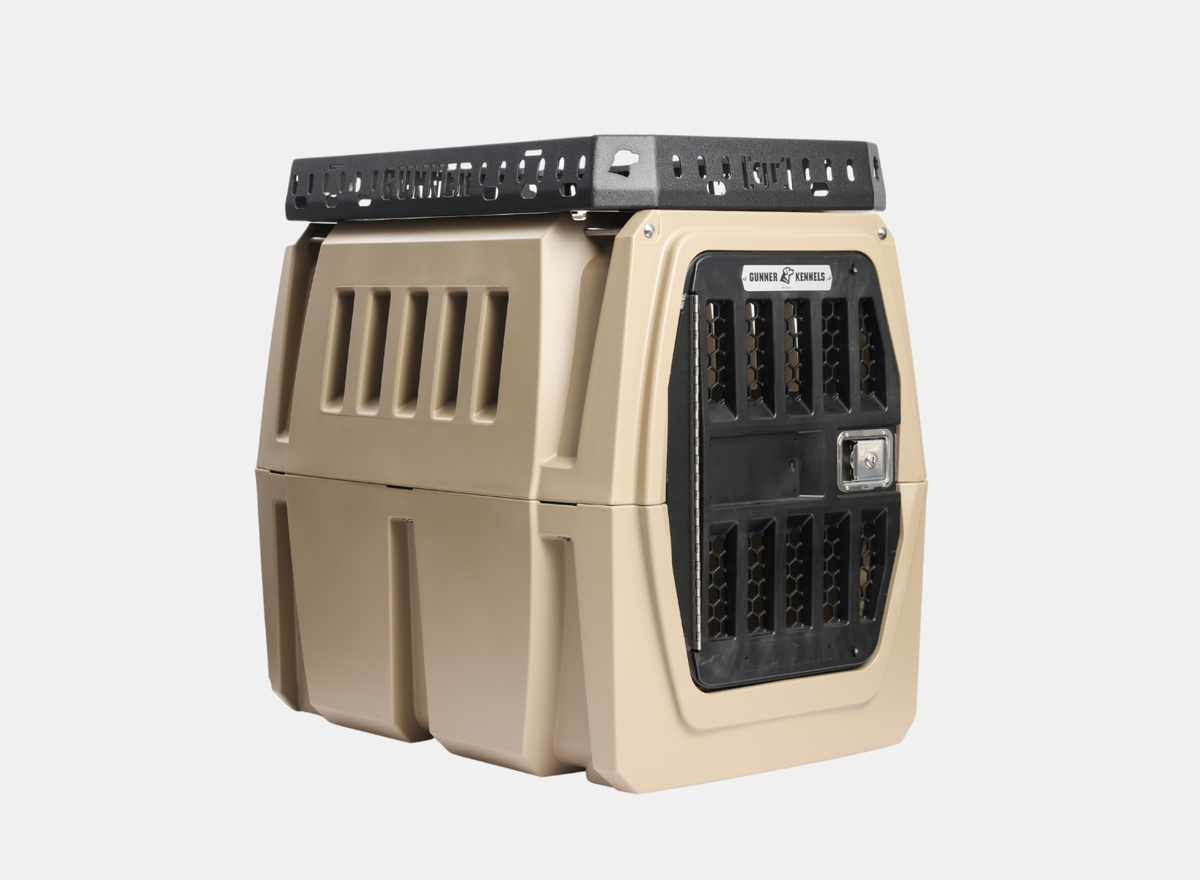 The GUNNER Kennel Rack BLACK is a tan and black hard-shell pet crate featuring ventilation slats on the sides and a metal front door, designed to fit seamlessly into a truck bed or integrate with a kennel storage system. It is shown placed against a plain white background.