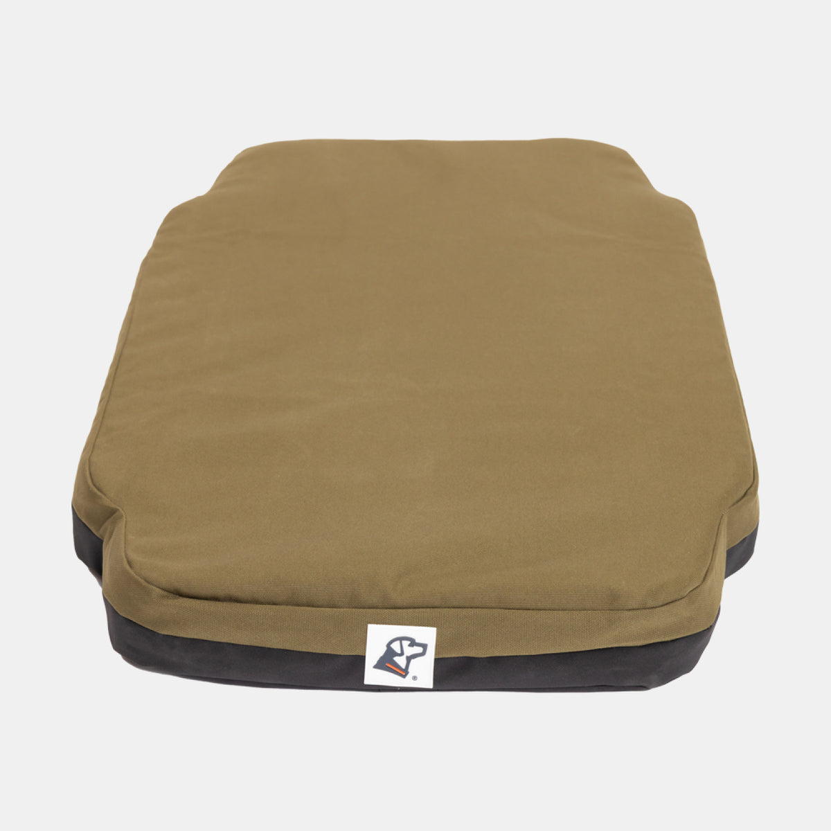 Rectangular olive green dog bed with a black base, featuring a small white tag with a dog logo on the front center. Designed to offer comfort and durability for your hardworking hunting dog or working dog after a long day, this bed is ideal for use in the home or kennel. The bed is placed on a plain white background.