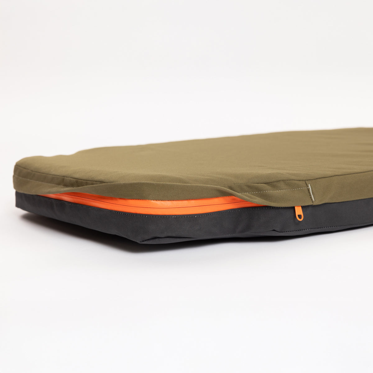 A flat, olive green and black zippered case with an orange zipper, photographed on a white background—perfect for organizing essentials in your hunting dog’s kennel or while on the go.