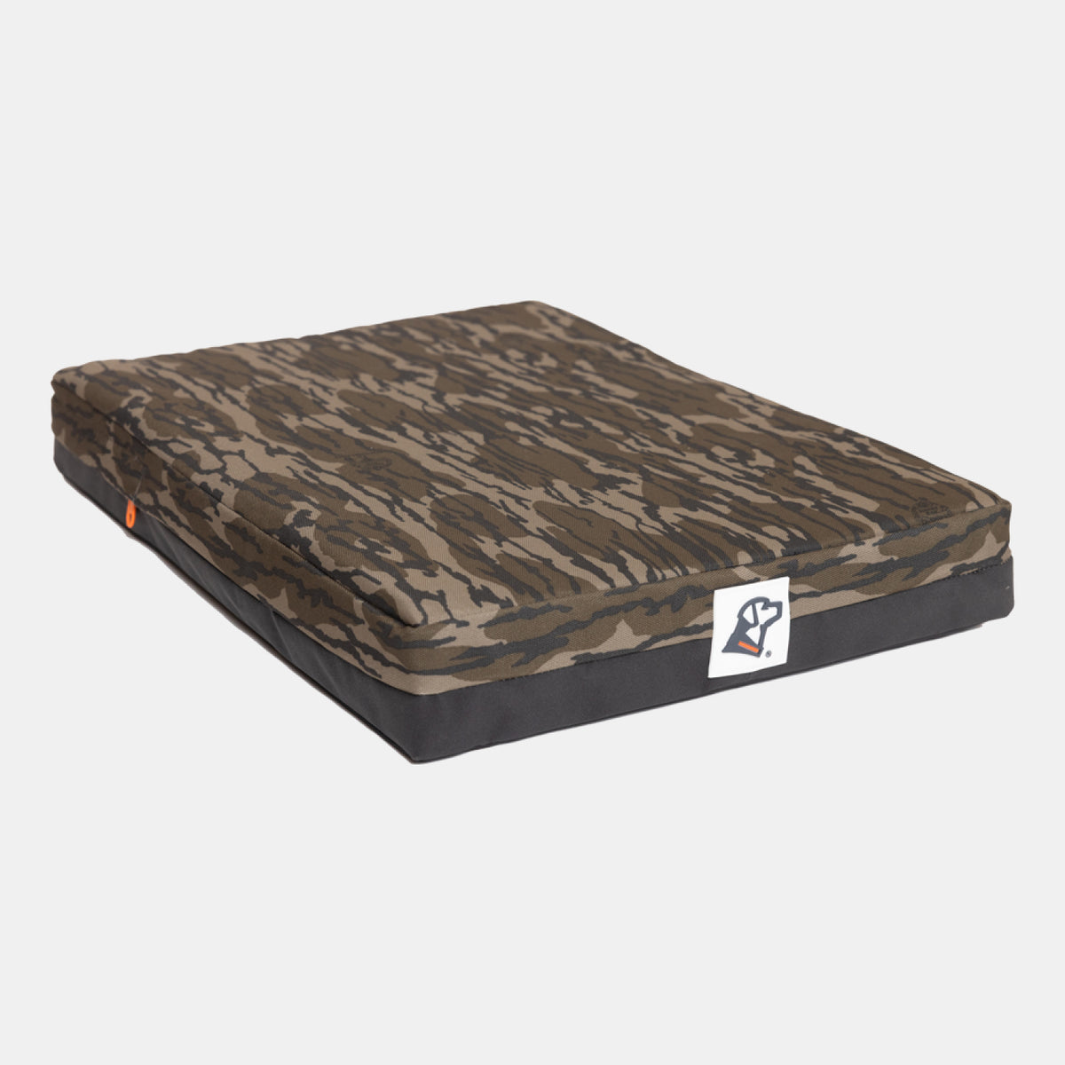 Rectangular dog bed with a brown and black camouflage pattern cover and a small white logo tag on the side, designed for the comfort of your hunting dog and ideal as part of your outdoor gear, shown on a plain white background.