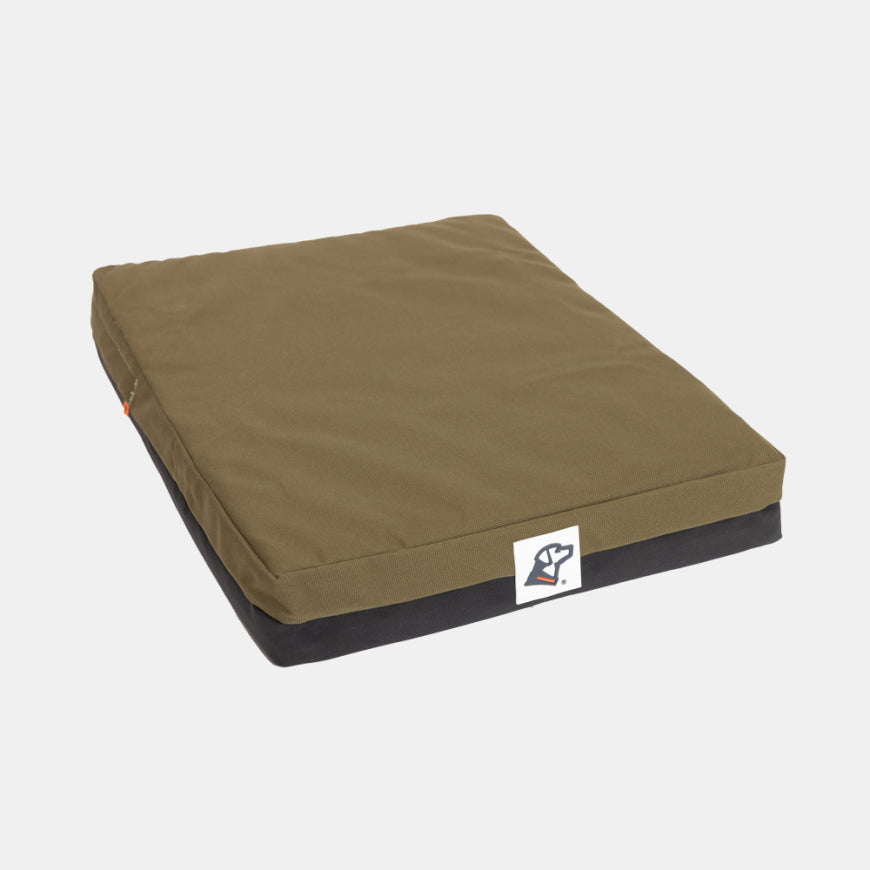 A rectangular olive green dog bed with a black base and a white logo tag on the front, designed for the comfort of your working dog, displayed on a plain white background.