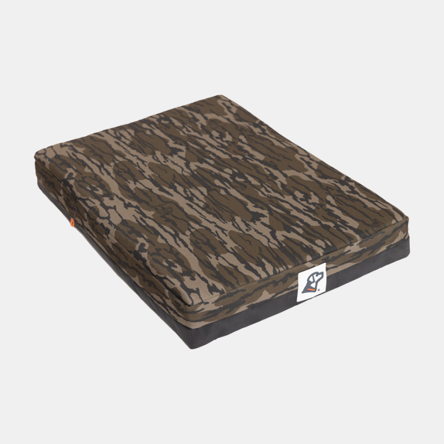 Rectangular cushion with a camouflage-patterned fabric cover—perfect for a dog kennel or dog crate—and a small white patch featuring a dog logo in the corner, placed on a plain white background.
