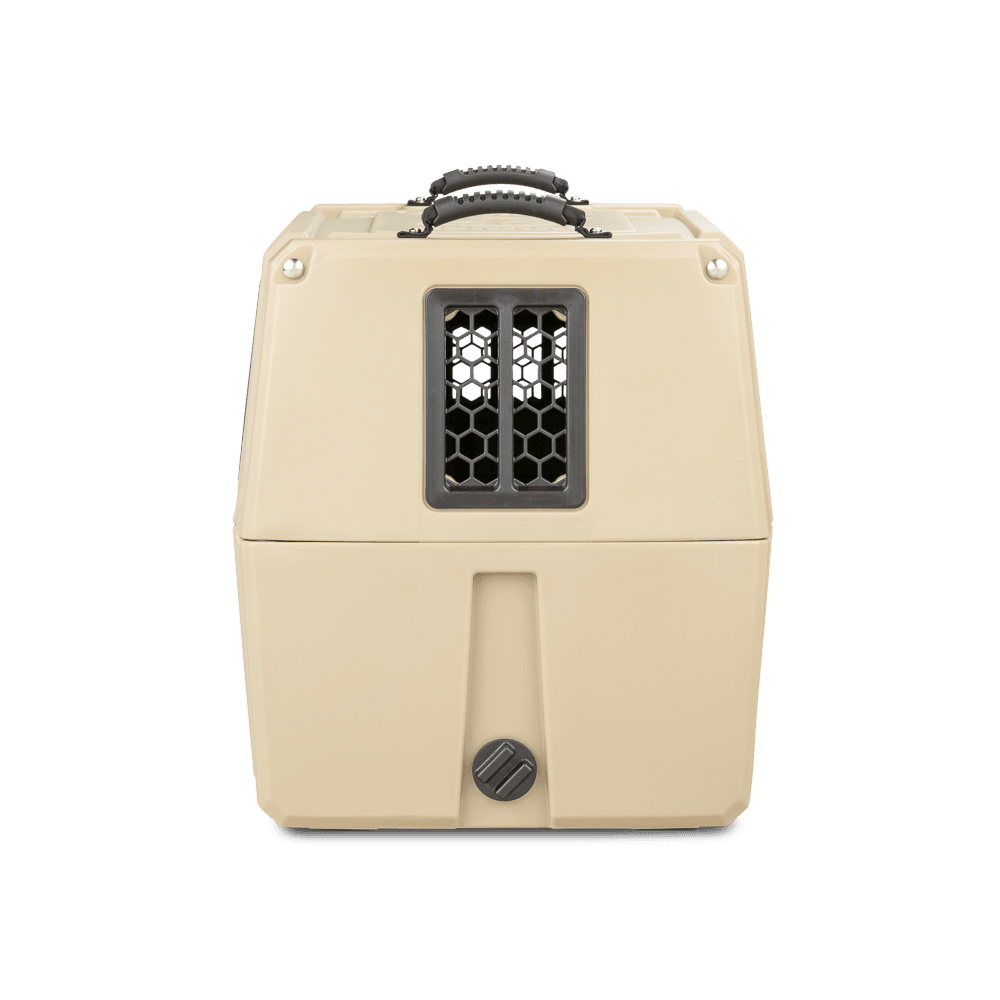 The GUNNER G1™ KENNEL - MOSSY OAK BOTTOMLAND TAN is a beige plastic dog crate with a black handle and a barred front window, shown closed against a plain white background.