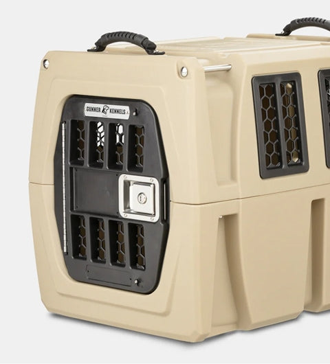 A sturdy beige plastic dog kennel with black metal door and side ventilation panels, featuring a secure locking mechanism and handles on top for easy carrying—ideal as outdoor gear for your pet.