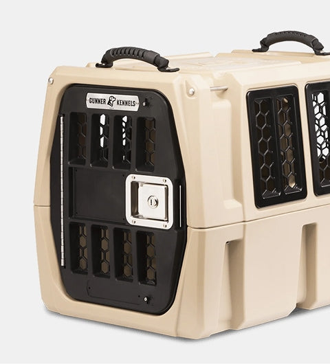 A beige and black hard-sided dog kennel with ventilation windows and a secure front door, designed for transporting animals safely. The crate is labeled “Gunner Kennels” above the door—ideal outdoor gear for your working dog.