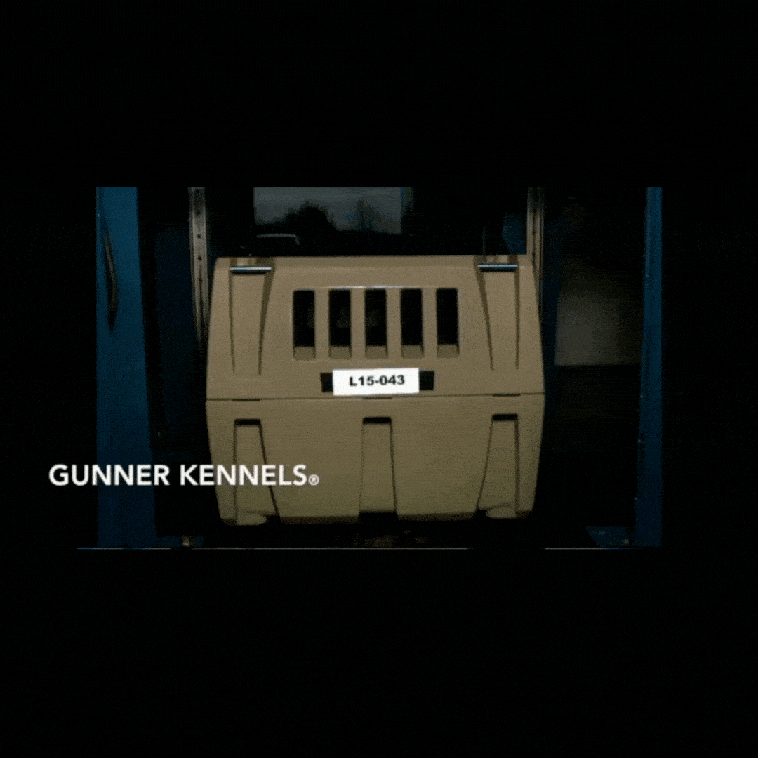 A tan GUNNER KENNELS dog crate is tested in a crash simulation, slamming into a barrier but remaining intact and upright, proving this kennels outstanding durability and safety for your pet.