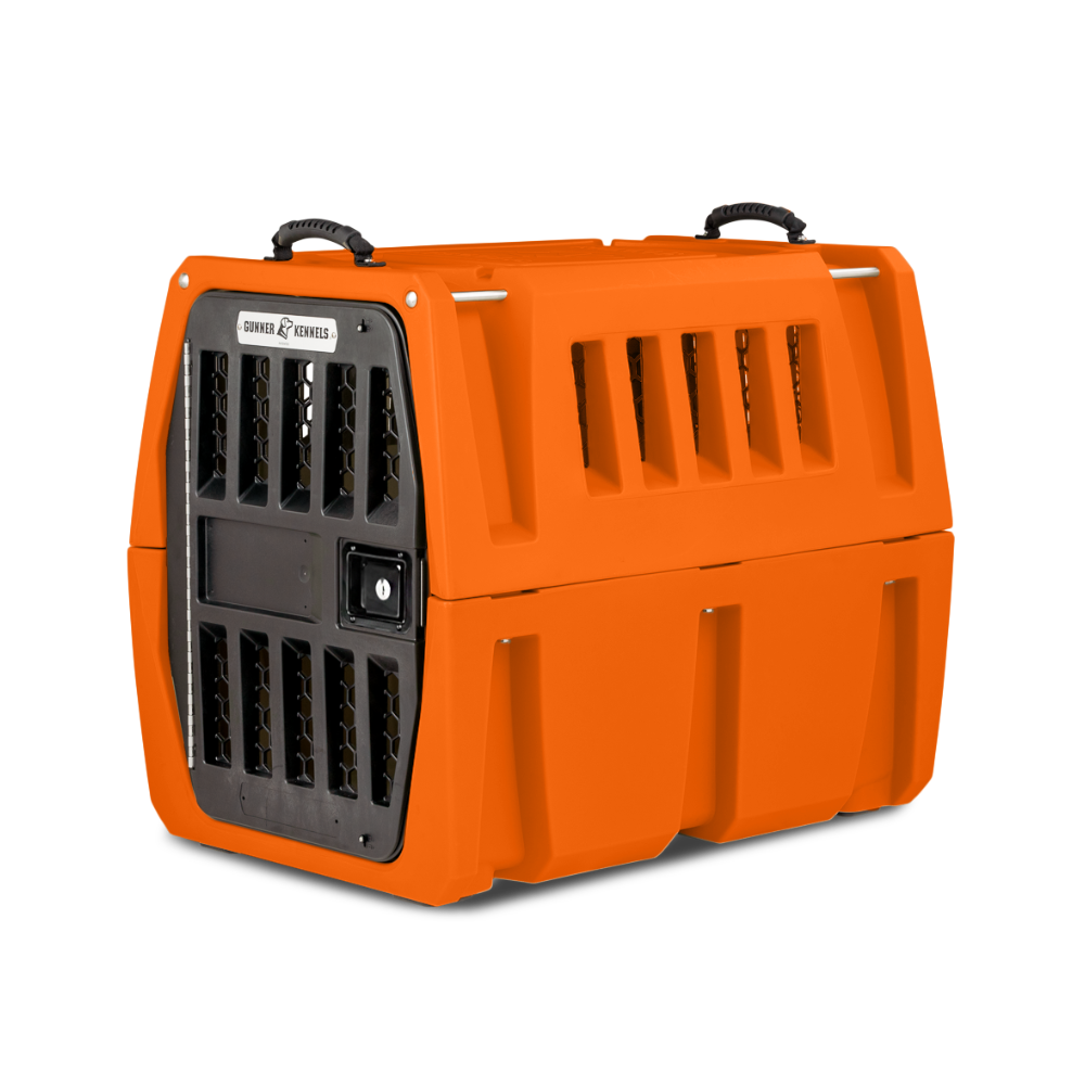 The GUNNER G1™ Kennel - GUNNER YARD is an orange, double-walled dog crate with a black metal grille door, side ventilation slats, and top handles—engineered for shock protection and safety during pet transport.