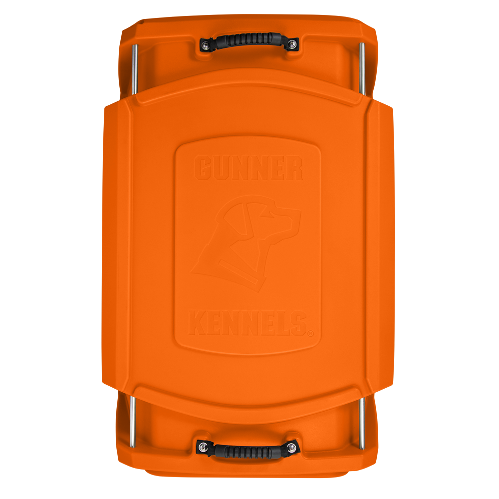 Top view of an orange dog crate kennel with black handles and the embossed Gunner Kennels logo featuring a dog’s head profile in the center—perfect for your working dog.