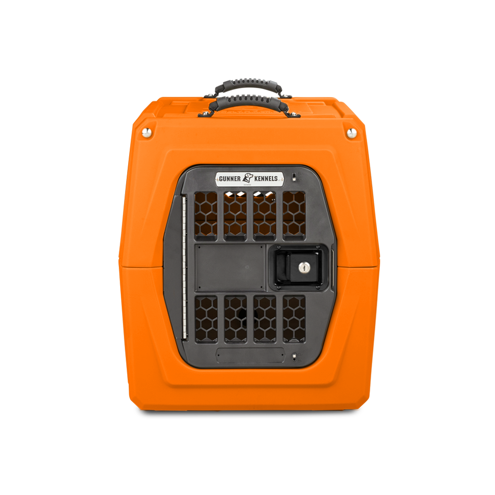 The GUNNER G1™ KENNEL - BLAZE ORANGE is a hard-sided dog crate with a black metal door, honeycomb-style vents, and a sturdy top handle.