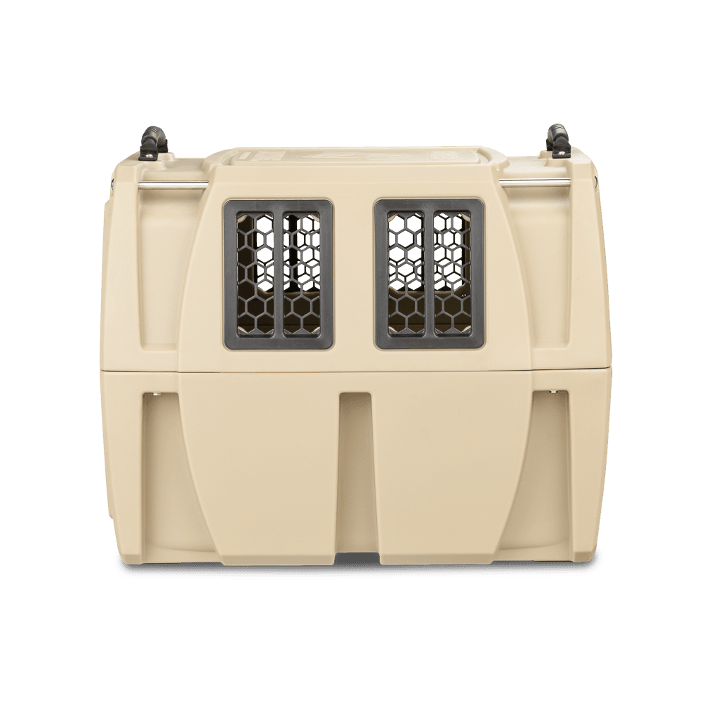 The GUNNER G1™ KENNEL - TAN is a beige double-walled pet carrier with two front black mesh windows and top handles, providing extra shock protection for comfort and safety, shown against a white background.