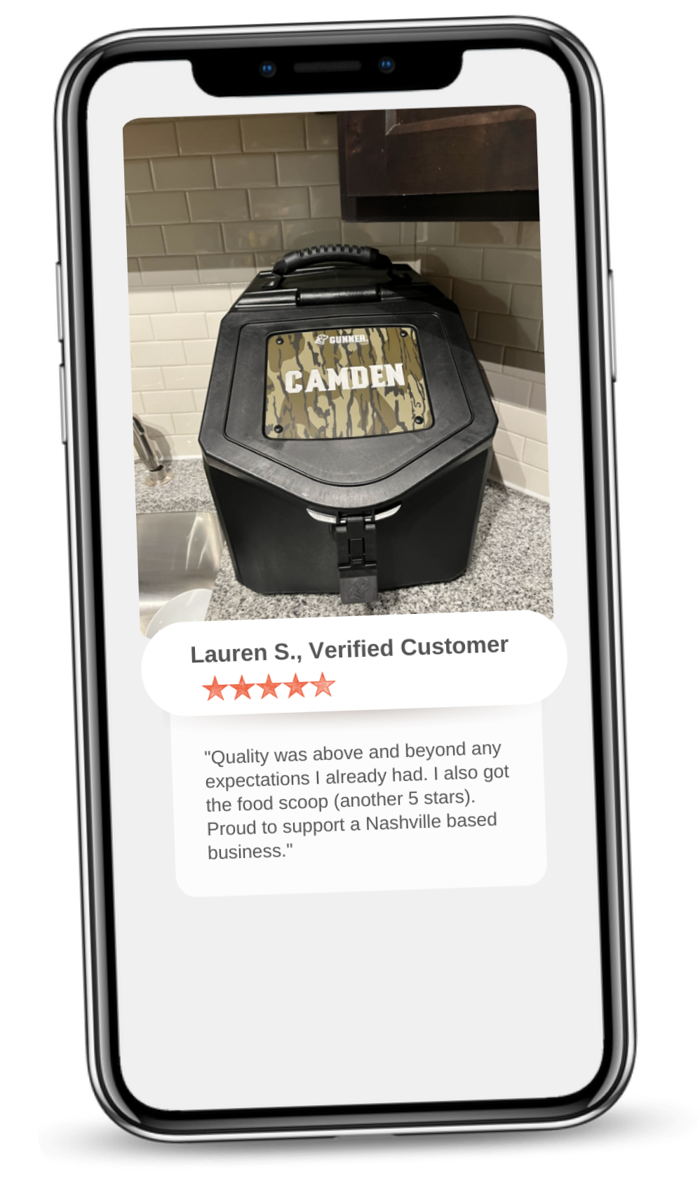 A smartphone displays a review of a product called CAMDEN, showing a black container on a kitchen counter. Below, Lauren S. gives a 5-star review praising the dog crate and supporting a Nashville business.