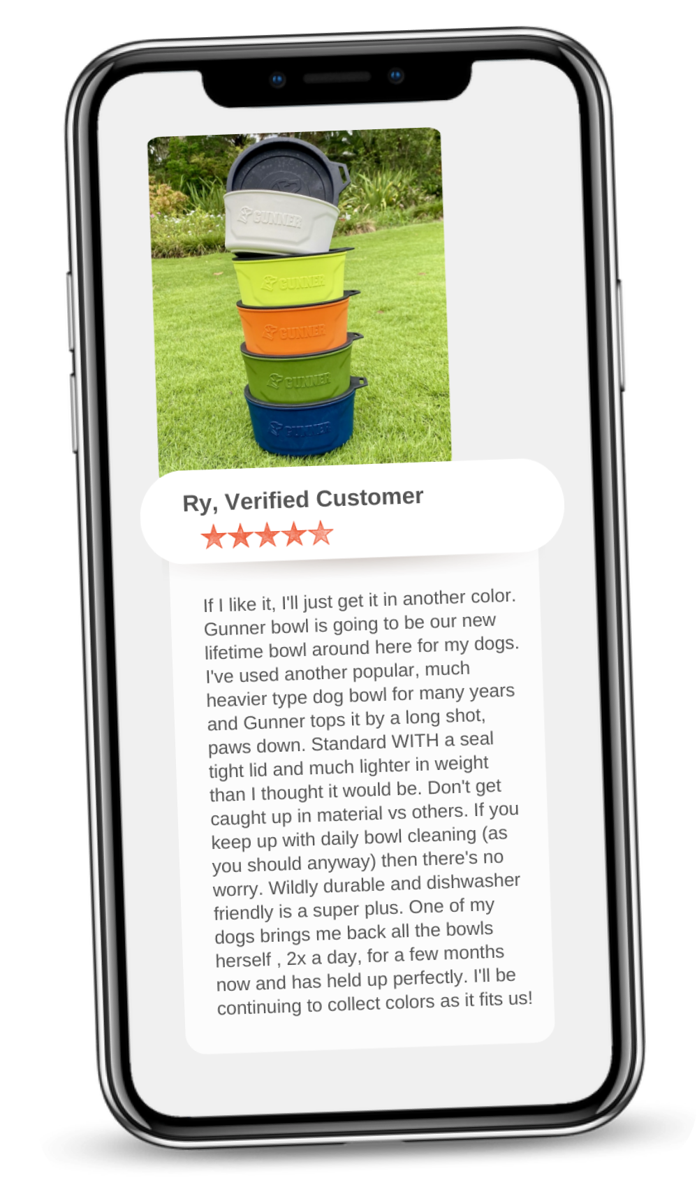 A smartphone displays a customer review for colorful dog bowls stacked in a pyramid on grass, perfect for use in any dog crate or kennel. The 5-star review from Ry, Verified Customer, highlights the bowls’ durability and convenience.